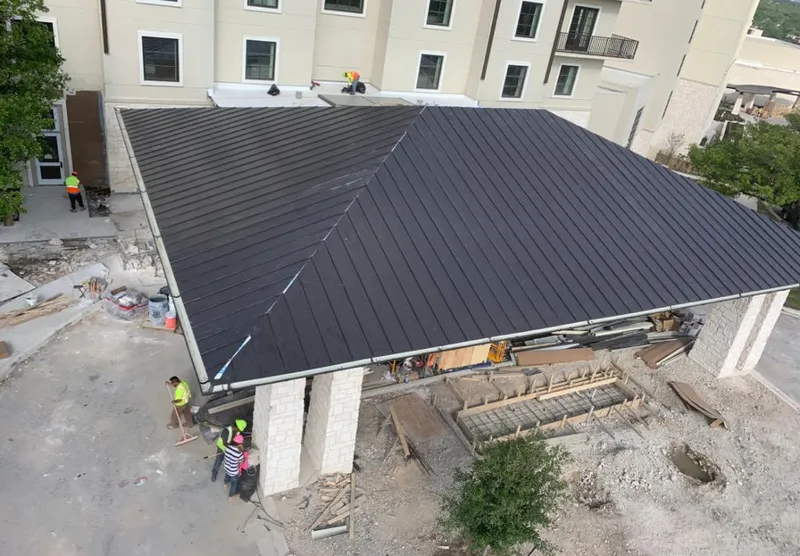 Metal roofing installation team working on a commercial building in Baton Rouge